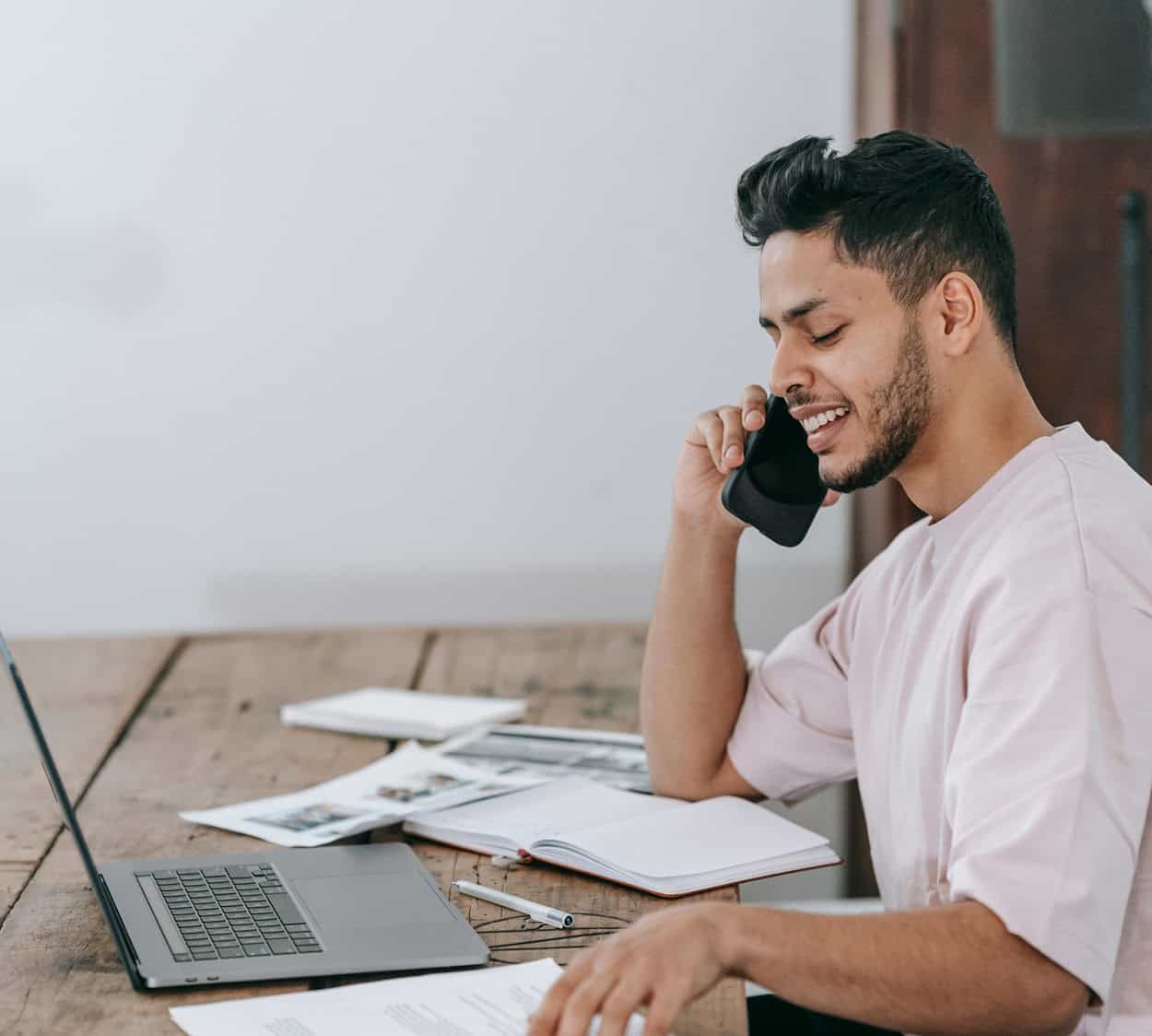 Man on the phone working on laptop after working with a cyber security for recruitment firms partner